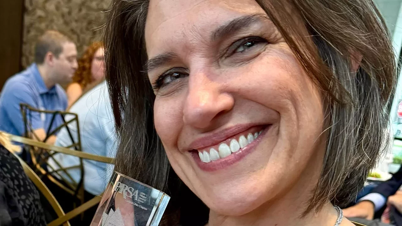 Sarah smiling with Central Ohio PRSA's Tom Poling “Practitioner of the Year” award